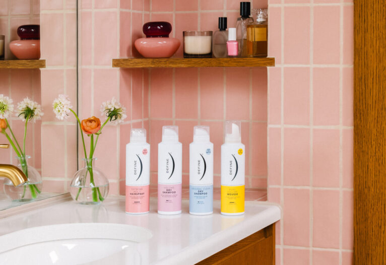 Fire stylingprodukter på rekke på baderomsvask, foran