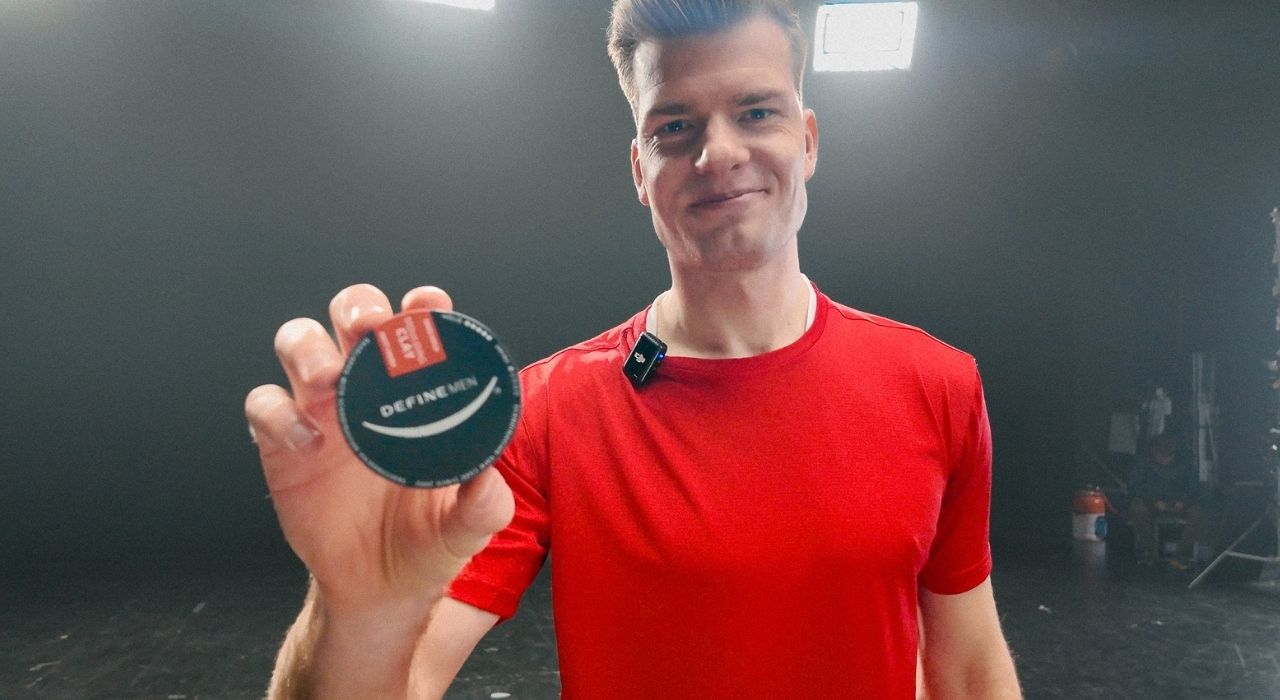 Alexander sørloth holder opp en boks med moulding clay-hårvoks på mørk bakgrunn